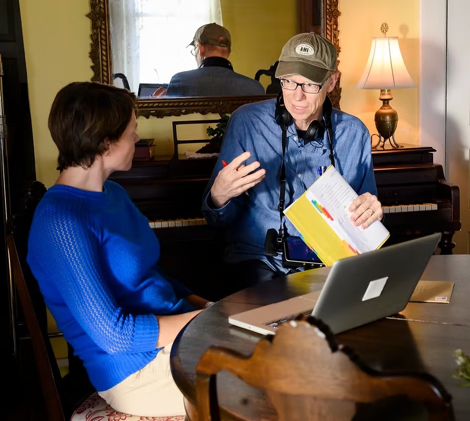 Terry Weston Marsh discussing a script with a collaborator, with headphones around his neck.